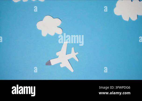Paper airplane cutout flying through white paper clouds against a blue ...