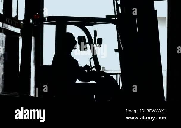 Strong backlight turns forklift operator into dark profile inside ...