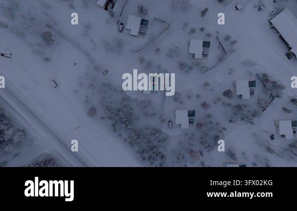 Snow In Athens High static top-down view over scattered snow-covered cabins with hot ...