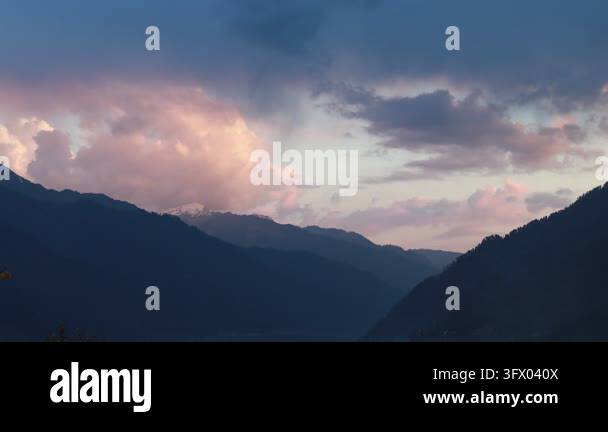 Sunset Time Frame Dramatic clouds illuminated by sunset light over dark mountain ...