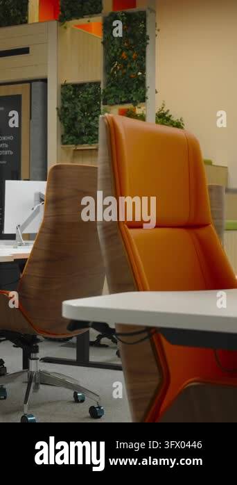 Bright open-plan office space with orange upholstered chairs, desks ...
