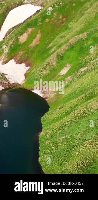 High-angle landscape of a rugged mountain ridge with dark rocky slopes ...
