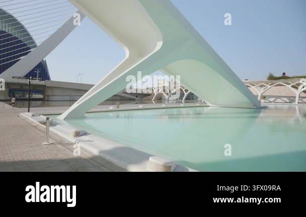 Large white sculptural bridge support arching over shallow turquoise ...