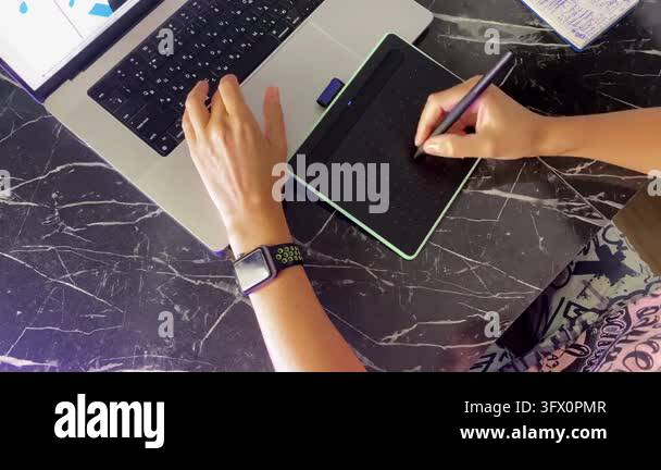 Person drawing on tablet, overhead view, then leaving the desk after a ...