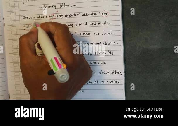 Calligraphy Letters Exercise Hand holding multicolor pen writing English sentences on lined paper ...