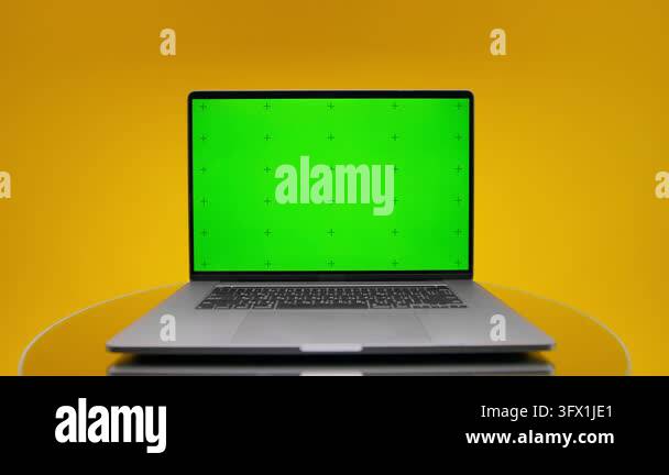 Wide composition shows laptop with green chroma key display and ...