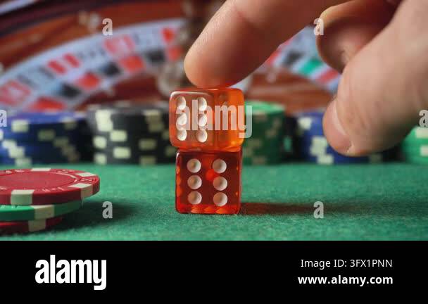 Video Card Position A hand gently positions a translucent orange die on top of another die ...