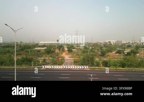Aerial drone footage tracking over a highway with distant city ...