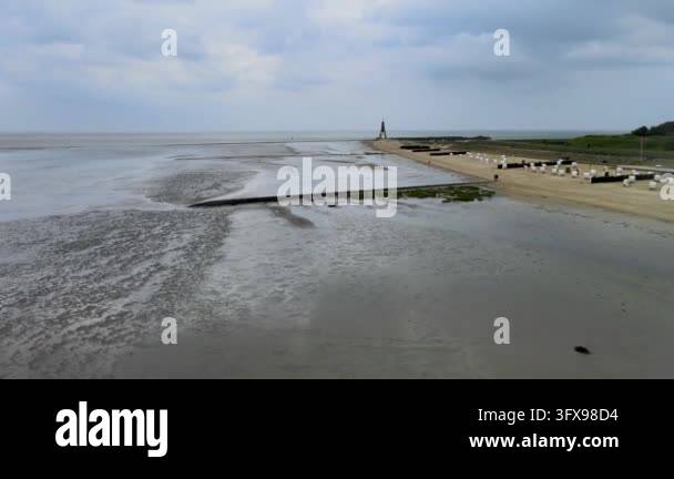 Aerial view of a wide, sandy beach with rows of beach chairs and a ...