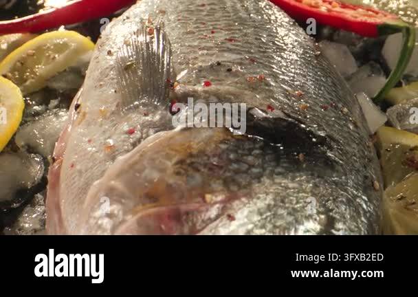 The preparation of fresh fish includes lemon and red chili placed on ...