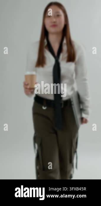 Vertical video front view of a young Asian woman in a white shirt and ...