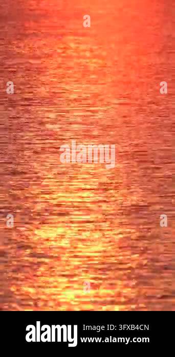 Water Ripple Effect 4k The sun sets over a calm body of water, casting warm orange and gold ...