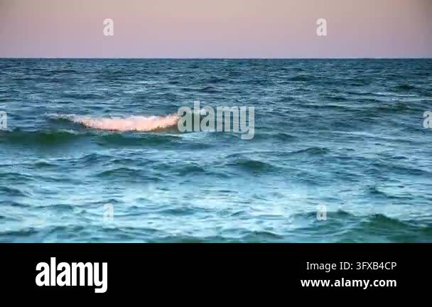 Ocean Color Scenes Waves gently move across the ocean surface during dusk. The horizon ...
