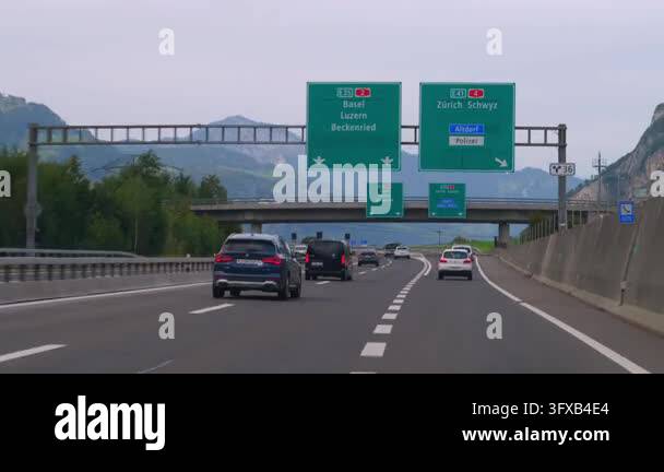 An Overhead Direction Sign Driving along a Swiss motorway with vehicles, overhead directional ...