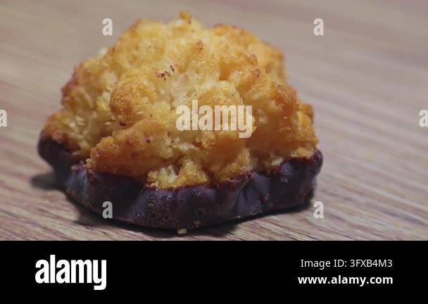 Snac Chocolate Crispy golden coconut macaroon dipped in dark chocolate sits on a ...