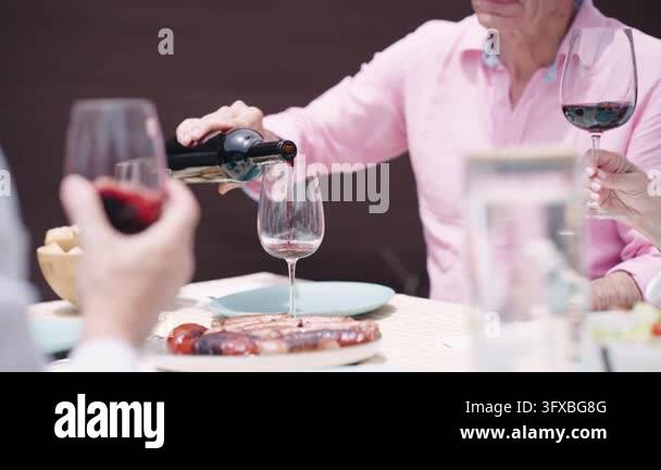 Happy group of mature friends enjoying a meal together. An elderly man ...