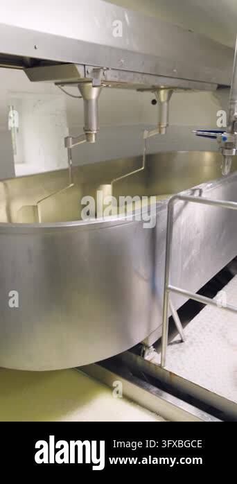 Large industrial machine stirring and mixing milk in a stainless steel ...