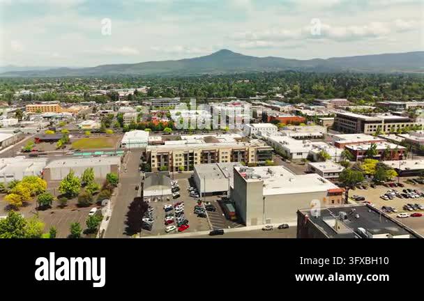 Drone footage looks across downtown Medford Oregon with urban blocks ...