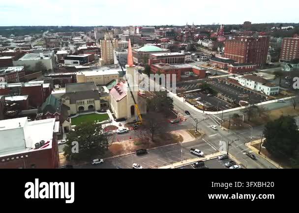 Aerial drone view shows a church with a tall steeple above downtown ...