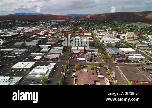Aerial view over downtown Yakima shows commercial buildings tree lined ...
