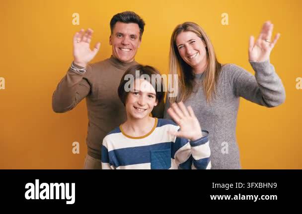 Happy family portrait with mother, father, and son waving hands ...