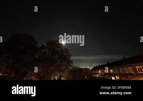 Contrals Time lapse of the moon and airplane contrails in the night sky over a ...