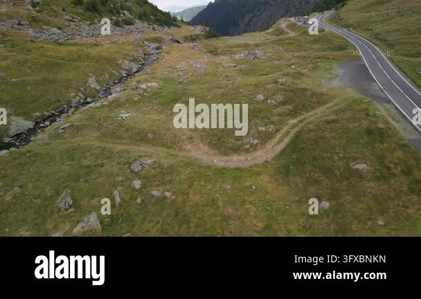 Rocky Stream Vector Aerial drone footage of a winding mountain road next to a rocky stream ...