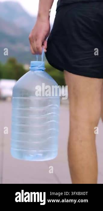 Close-up of a hand carrying spring water, a simple ritual to support ...