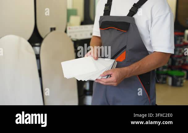 Male painter in work uniform selecting the perfect shade from a color ...