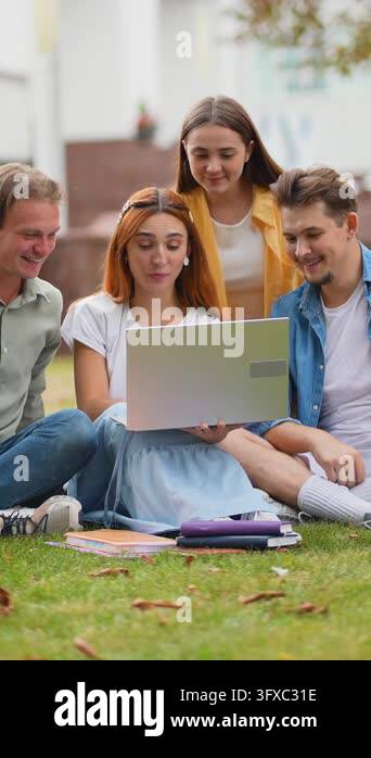 Young diverse students collaborating on a project using a laptop ...