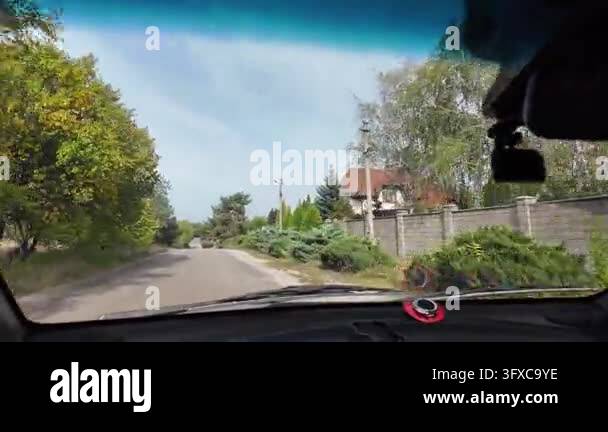 First-person POV walking along a narrow rural dirt road between garden ...