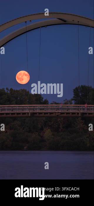 Sunset Time Frame Time-lapse of a full moon rising above a pedestrian bridge over the ...