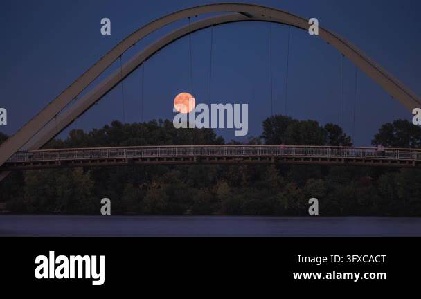 Sunset Time Frame Time-lapse of a full moon rising above a pedestrian bridge over the ...