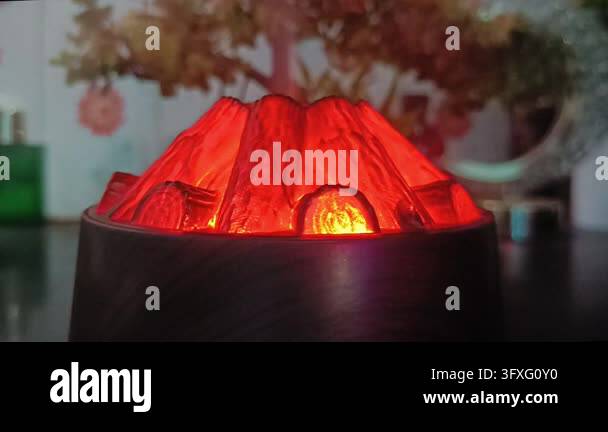 Valcano Red Close view of glowing red volcano diffuser with faux tree decor in ...