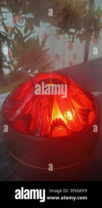 Valcano Red Volcano shaped mist diffuser glowing red on desk near artificial plant ...