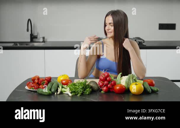 Fit woman presenting fresh vegetables and fruits for healthy eating ...