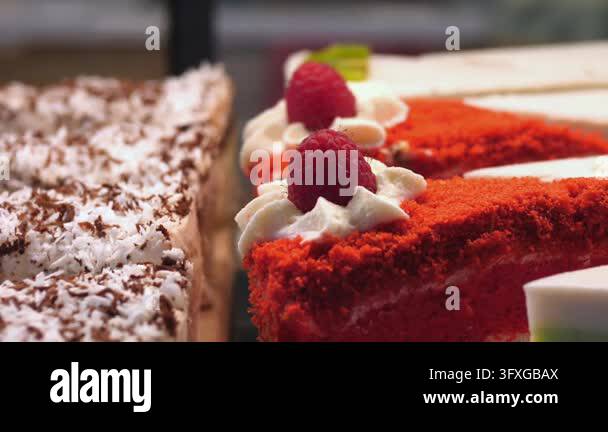 Vibrant Raspberry Colour Red velvet cake slice with raspberry and whipped cream rests beside ...