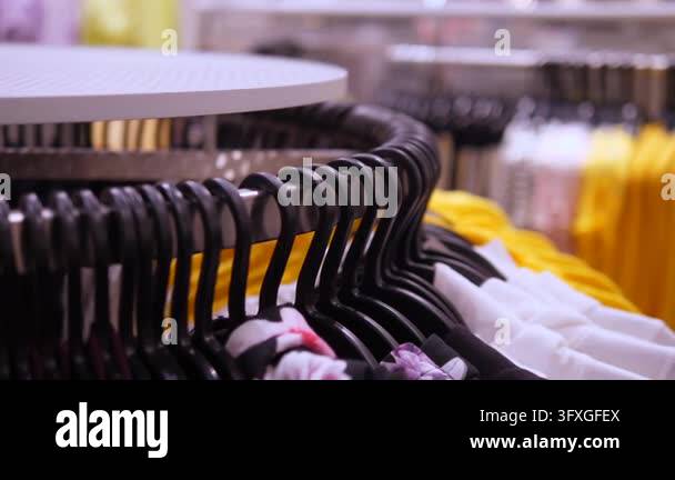 Store apparel rack shows neatly hung shirts in fashion retail setting ...