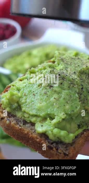 Toast Spoon Avocado toast gets seasoned on rustic bread. Close food preparation ...