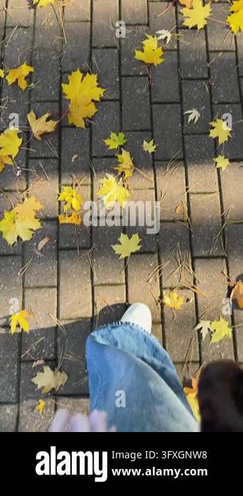 Downward camera angle shows person walking forward on brick pavers with ...