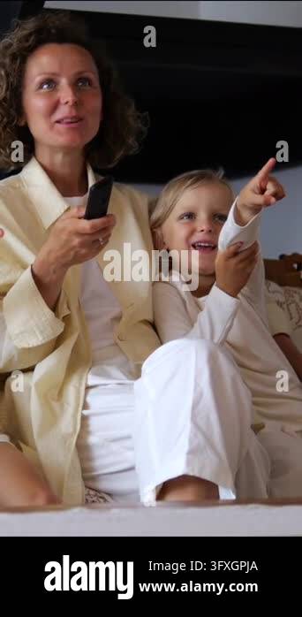 Remote Control Screen Tv Mother and child share tv time on sofa, both looking off screen with ...