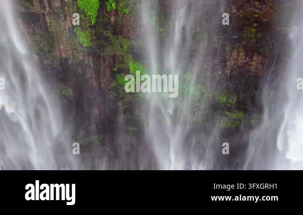 High altitude drone shot showcasing cascading water, mist and mossy ...