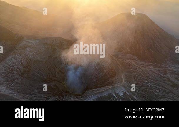 Volcano Smoking Golden light bathes a smoking volcano Mount Bromo. Steam rises from the ...