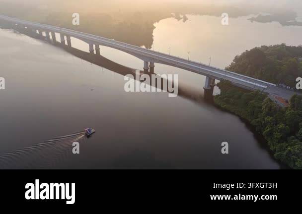 Rivers With Ripples Aerial shot of a long modern bridge crossing a calm river at sunrise ...