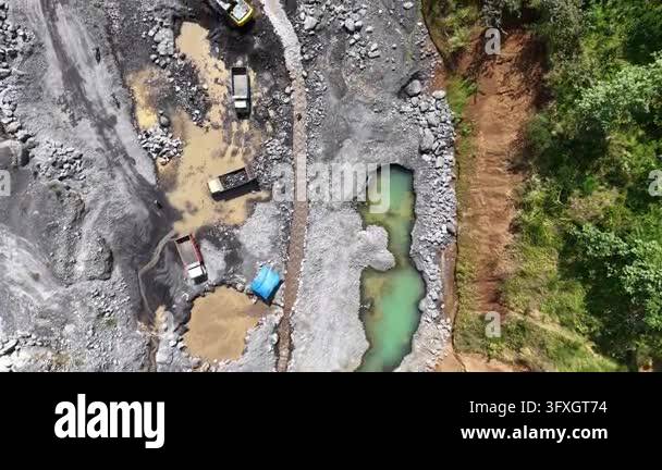 High angle drone view of heavy machinery harvesting natural gravel ...