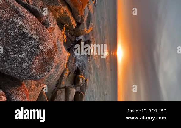 Golden Sunset Over Calm Ocean with Rocky Shore and Coastal Waves Stock ...