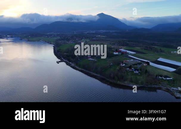 Aerial drone footage flying over a calm river and a rural landscape ...