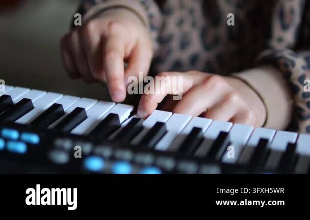 Finger/hand Framing Child learns piano at electronic keyboard, using one finger to find ...