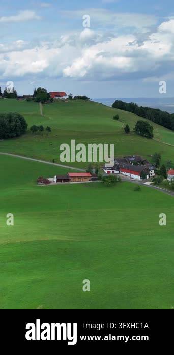 Picturesque alpine farm amidst the green hills of Europe. Panoramic ...