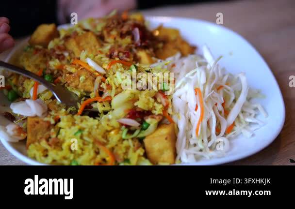 Is There Healthy Rice Vegetable fried rice and tofu are stirred with fork beside shredded ...